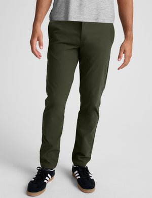 model wearing green men's chino pants on a plain background.