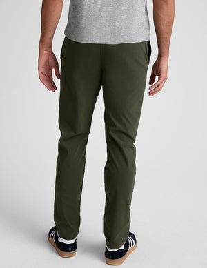 model wearing green men's chino pants on a plain background.