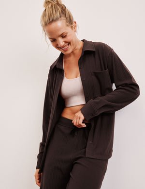 model wearing a brown ribbed button down top and brown ribbed pants against a plain background.