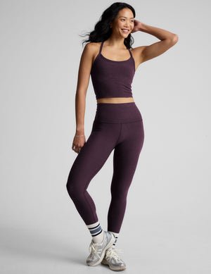purple slim racerback cropped tank top and purple leggings on a plain background.